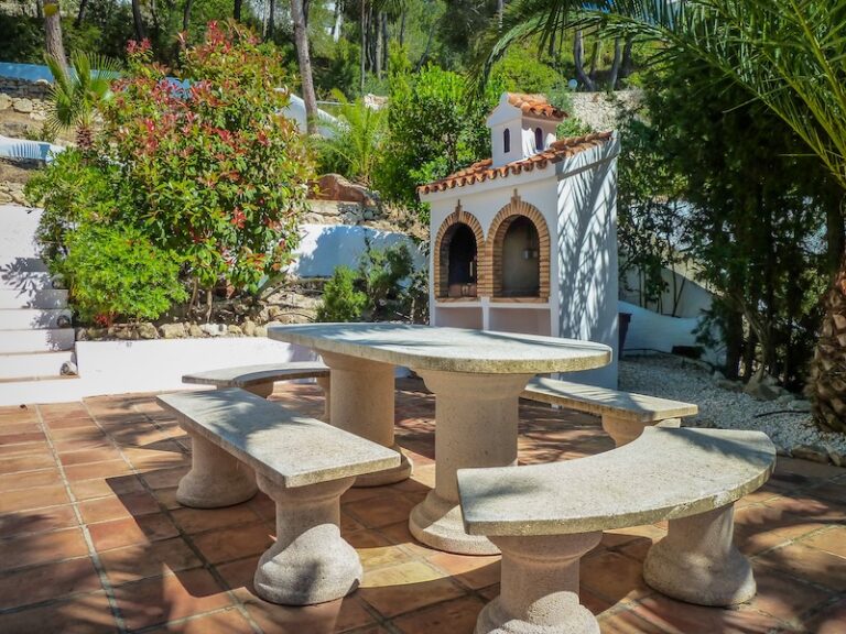 Built-in barbecue area with stone table and benches